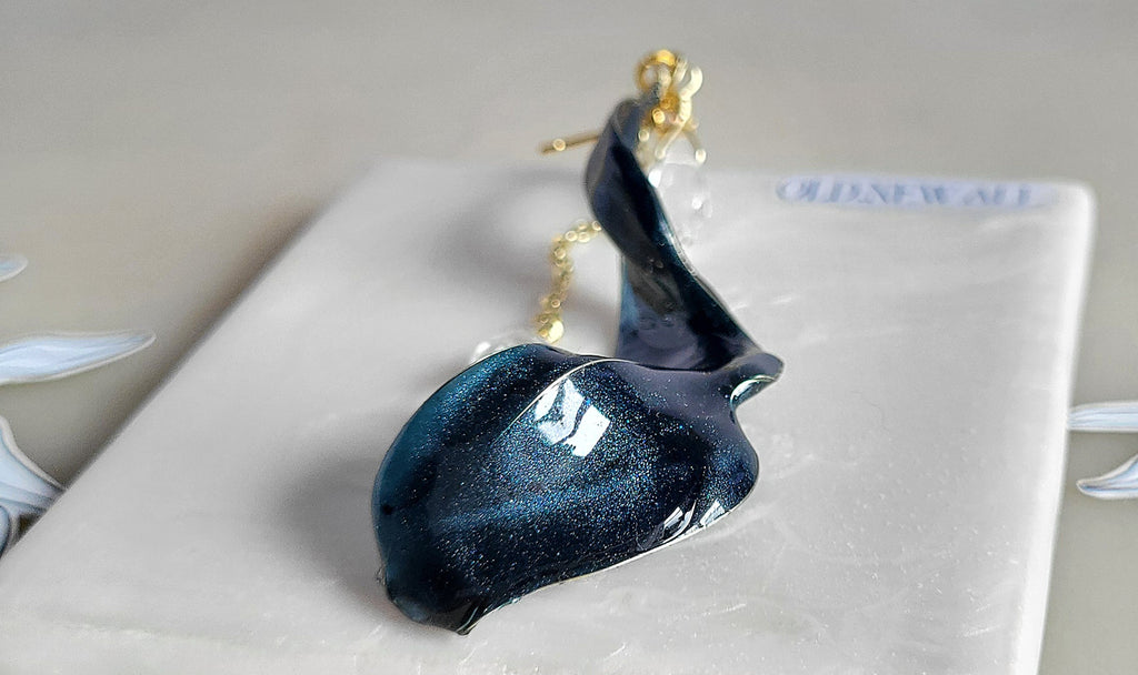 Handcrafted long gold wire earrings with navy blue starry cat eye resin flowers, zirconia starburst crystal studs, waterdrop crystals, and raindrop dangles.