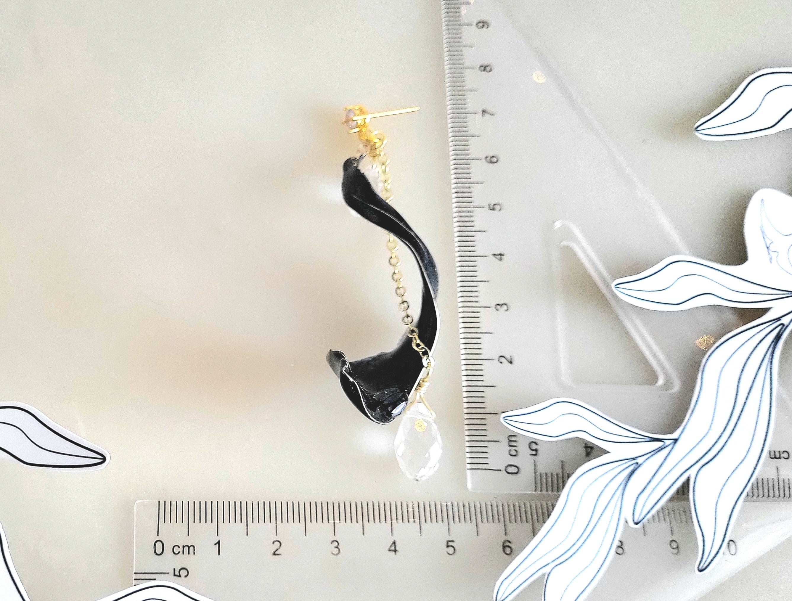 Handcrafted long gold wire earrings with navy blue starry cat eye resin flowers, zirconia starburst crystal studs, waterdrop crystals, and raindrop dangles with ruler