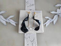Handcrafted long gold wire earrings with navy blue starry cat eye resin flowers, zirconia starburst crystal studs, waterdrop crystals, and raindrop dangles.