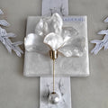 Handcrafted extra large mother of pearl silk flower brooch in white orchid design with gold wire petals and secure pin findings.