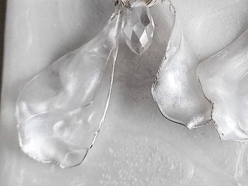 close up Handcrafted white mother-of-pearl resin earrings on silver french hooks with clear crystal suncatcher waterdrops