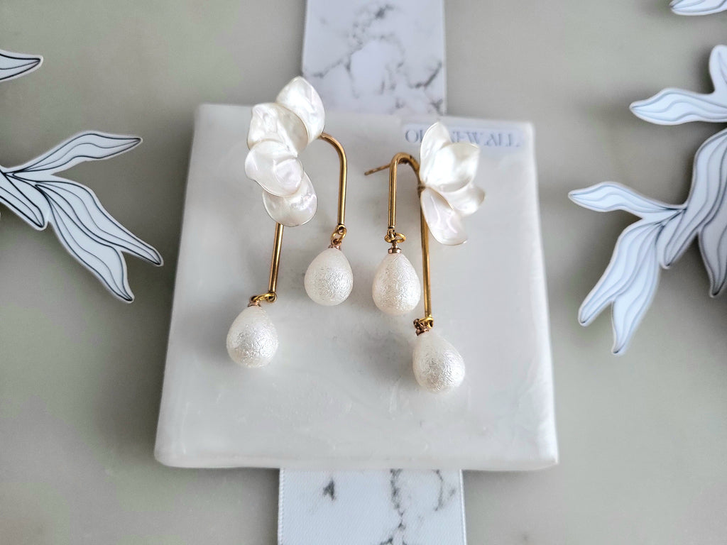 White orchid resin earrings featuring elegant waterdrop faux pearl charms, perfect for a bridal wedding look.