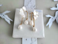White orchid resin earrings featuring elegant waterdrop faux pearl charms, perfect for a bridal wedding look.