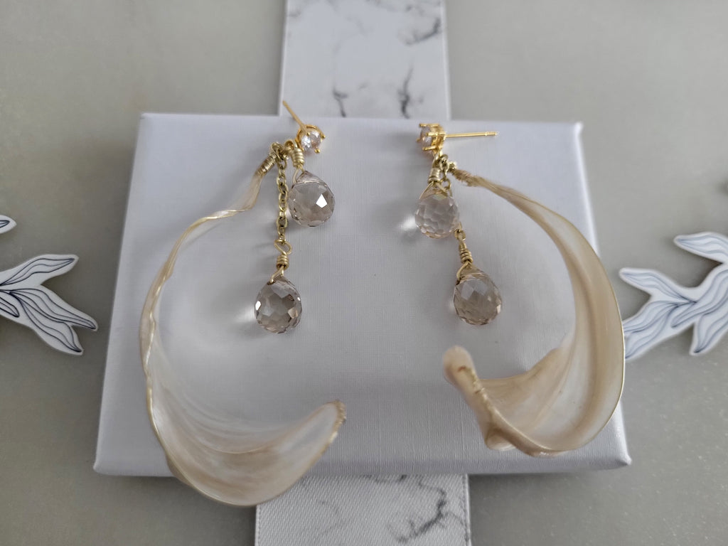 Handcrafted long gold wire earrings with ivory mother of pearl resin flowers on a delicate chain with sparkling champagne crystal drops.