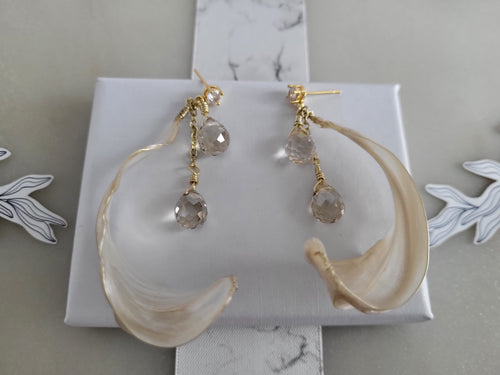 Handcrafted long gold wire earrings with ivory mother of pearl resin flowers on a delicate chain with sparkling champagne crystal drops.