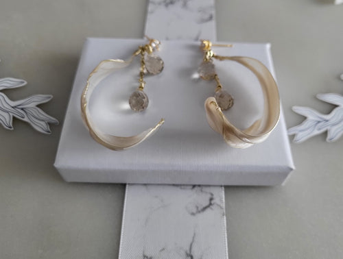 Handcrafted long gold wire earrings with ivory mother of pearl resin flowers on a delicate chain with sparkling champagne crystal drops.