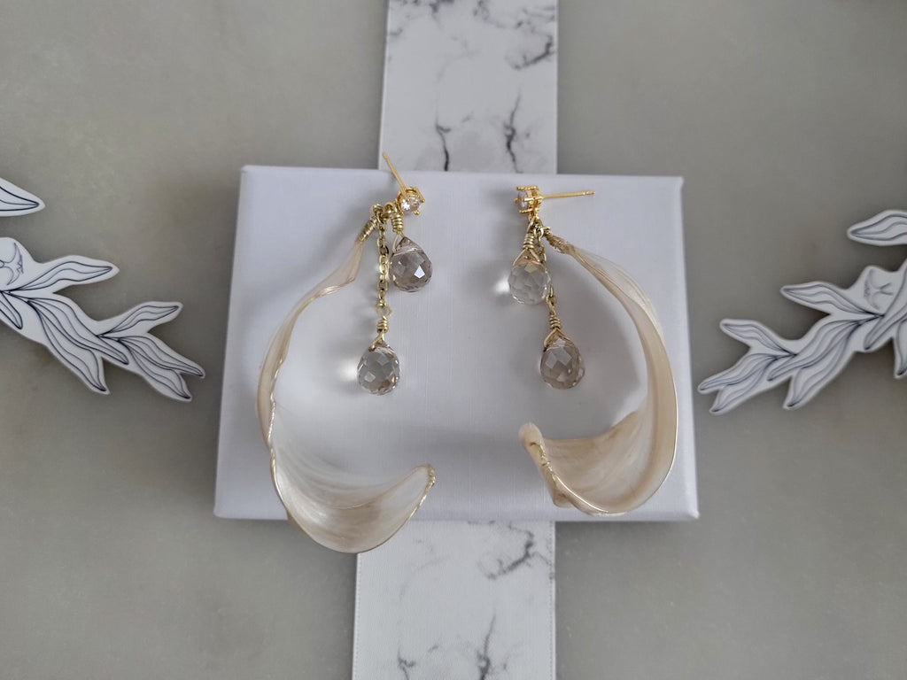 Handcrafted long gold wire earrings with ivory mother of pearl resin flowers on a delicate chain with sparkling champagne crystal drops.