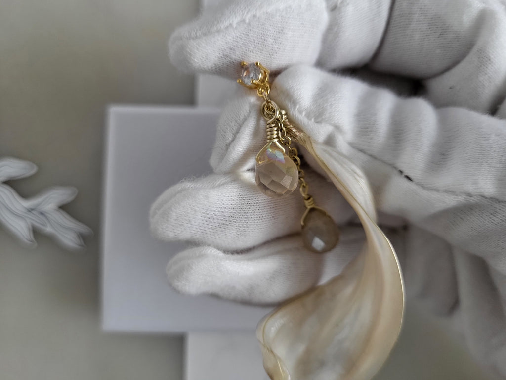 Handcrafted long gold wire earrings with ivory mother of pearl resin flowers on a delicate chain with sparkling champagne crystal drops.