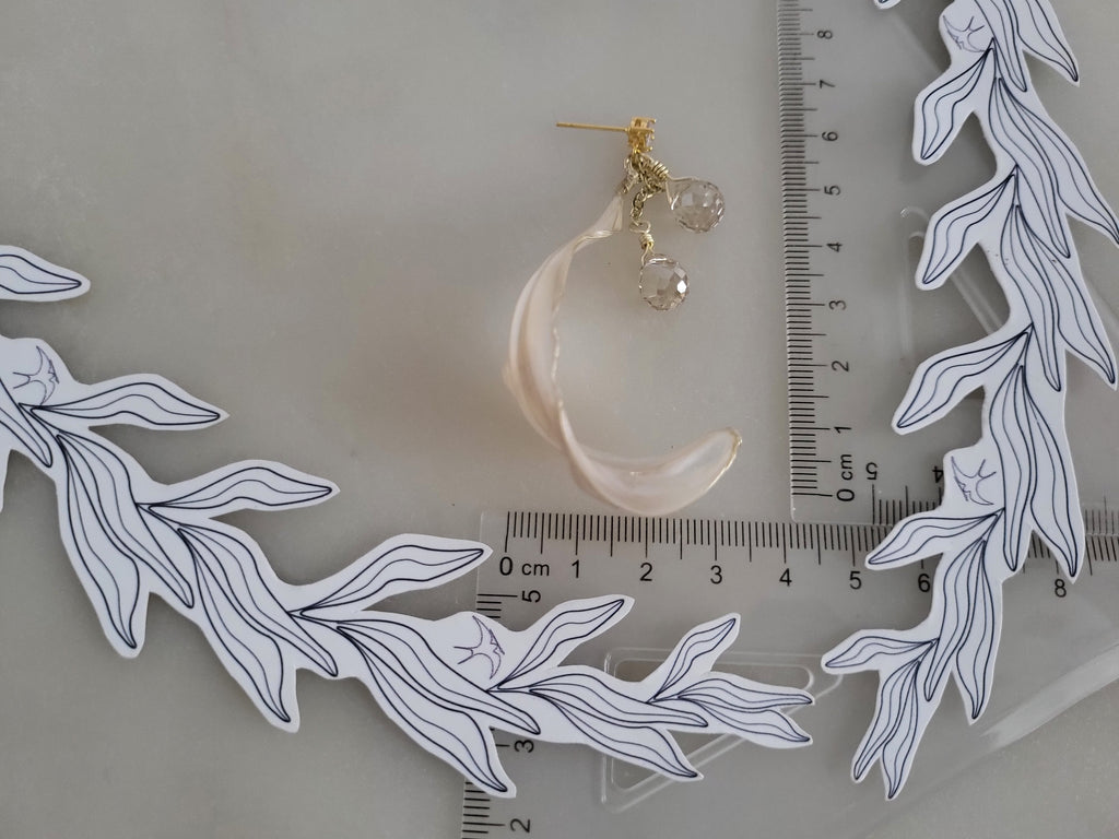 Handcrafted long gold wire earrings with ivory mother of pearl resin flowers on a delicate chain with sparkling champagne crystal drops with a ruler