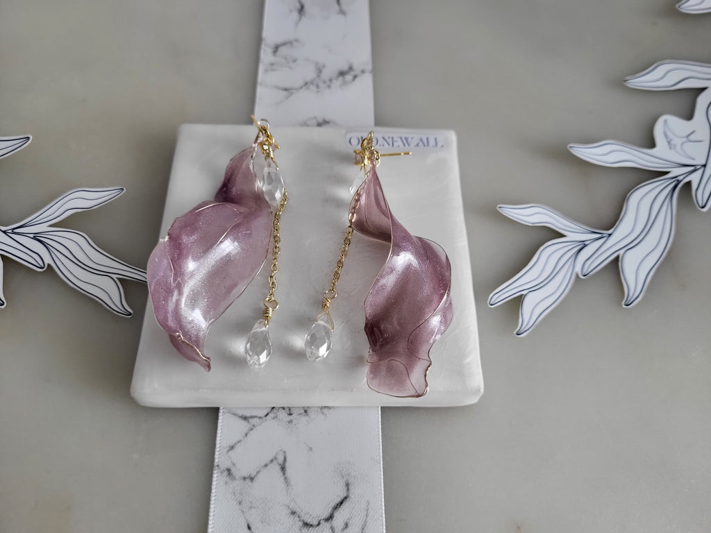 Handcrafted long golden wire earrings featuring pink cat eye resin flowers on a delicate chain with zirconia studs, waterdrop crystals, and raindrop dangles.