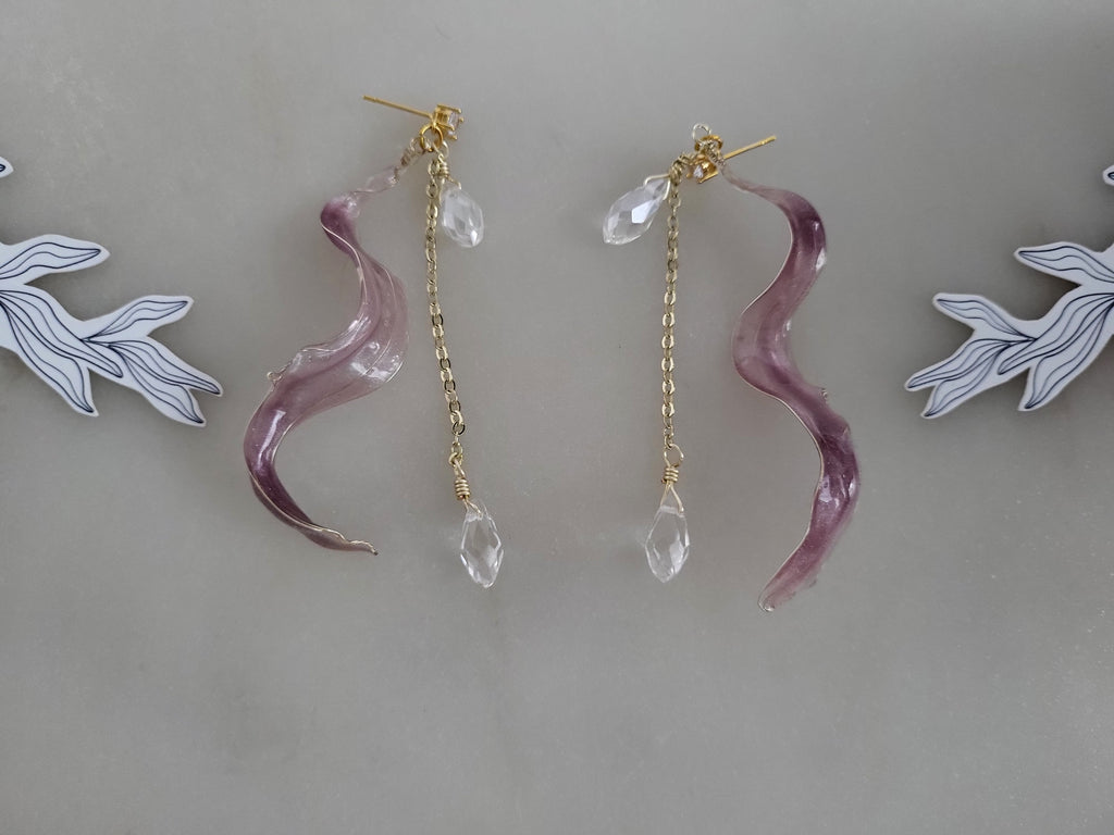 Handcrafted long golden wire earrings featuring pink cat eye resin flowers on a delicate chain with zirconia studs, waterdrop crystals, and raindrop dangles.