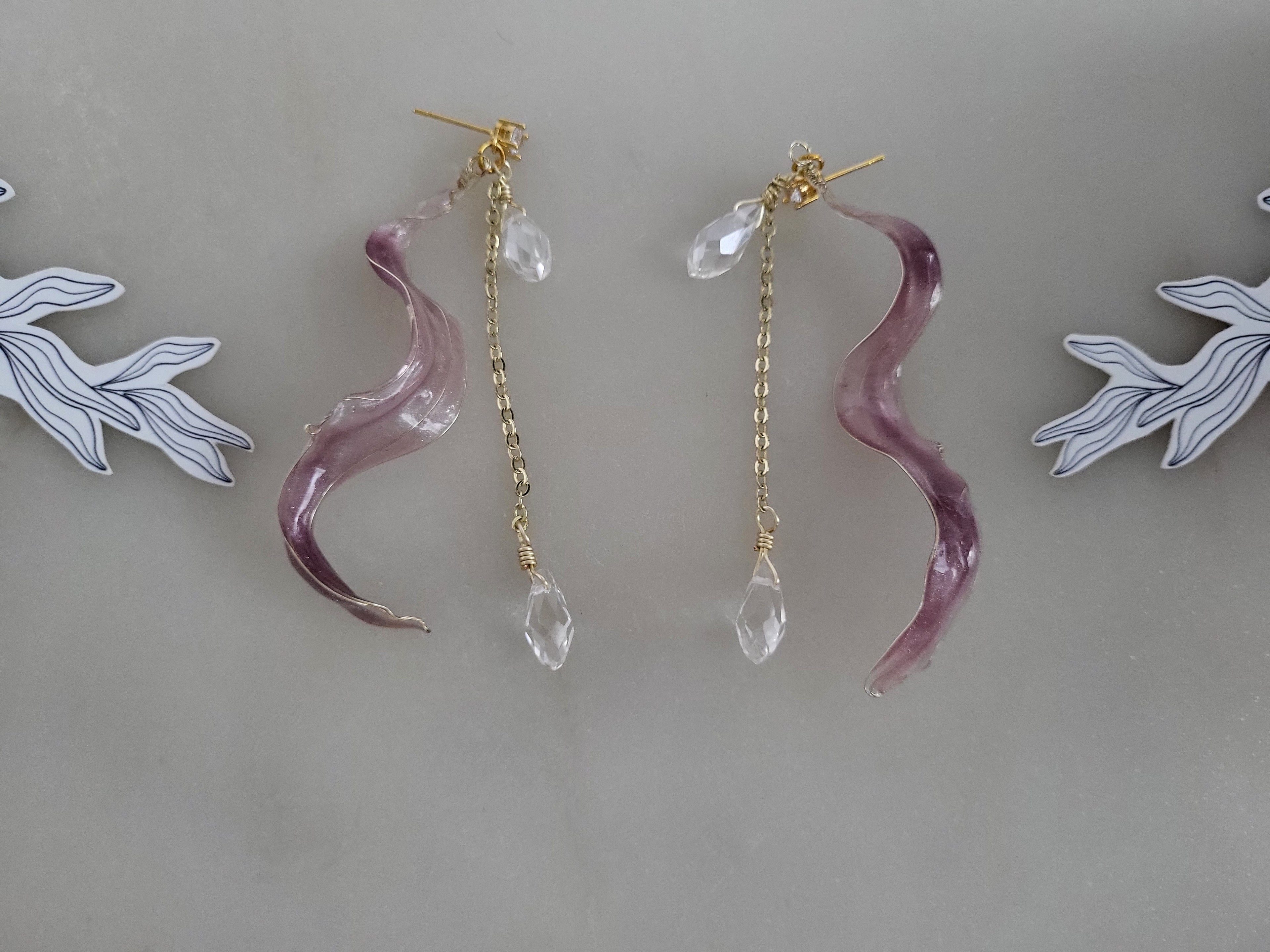 Handcrafted long golden wire earrings featuring pink cat eye resin flowers on a delicate chain with zirconia studs, waterdrop crystals, and raindrop dangles.
