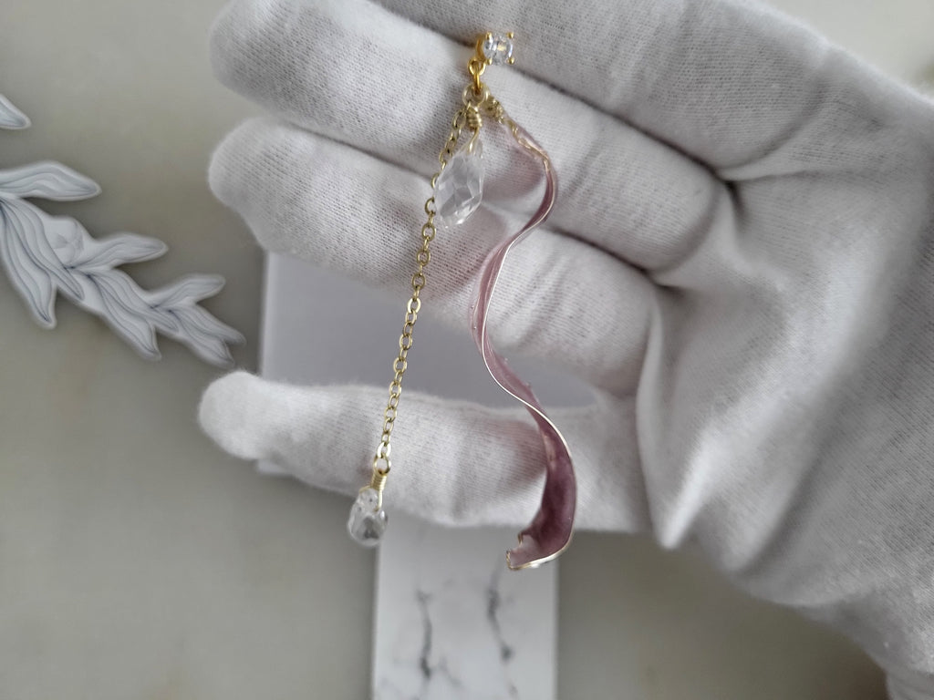 Handcrafted long golden wire earrings featuring pink cat eye resin flowers on a delicate chain with zirconia studs, waterdrop crystals, and raindrop dangles.