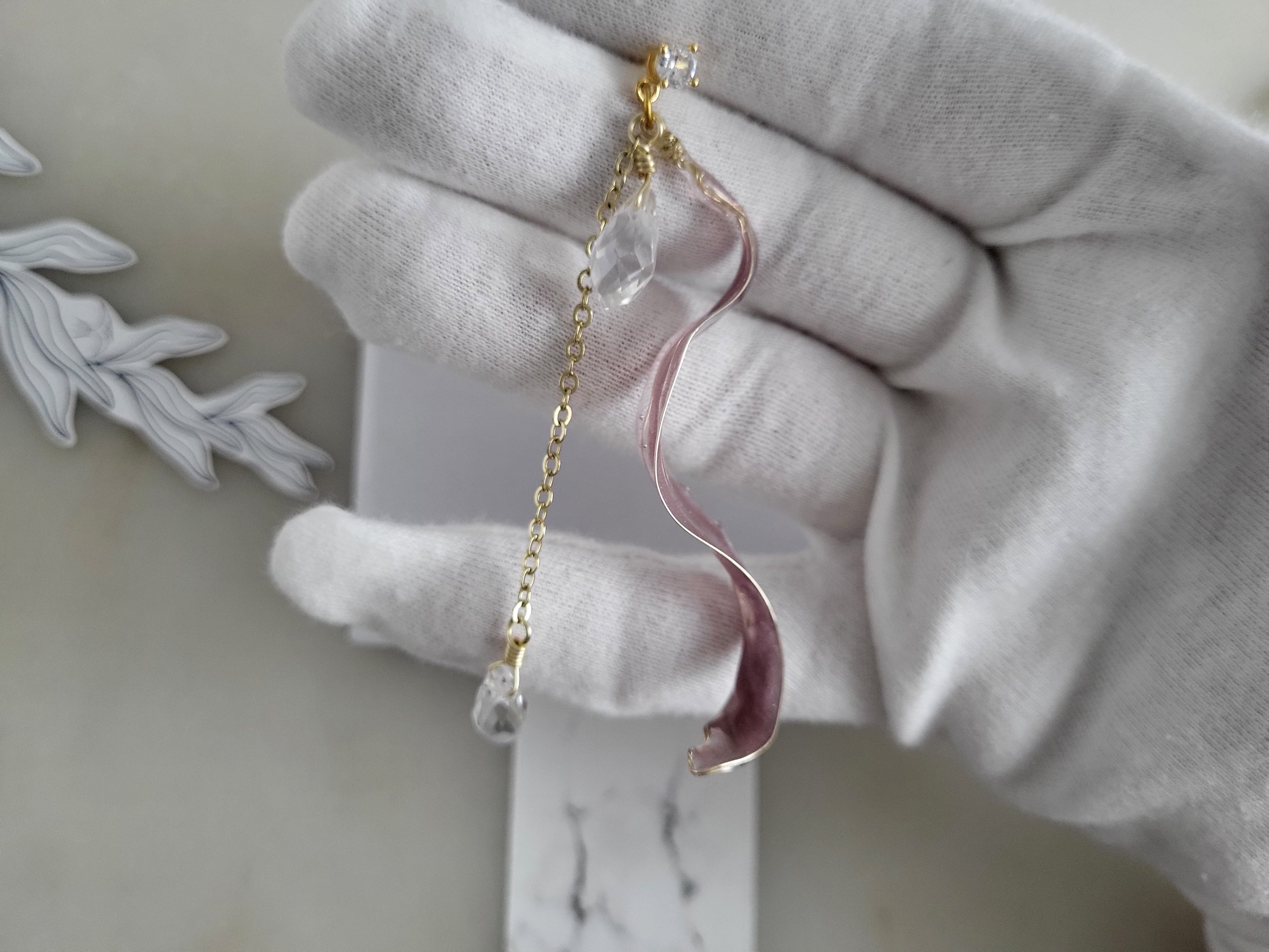 Handcrafted long golden wire earrings featuring pink cat eye resin flowers on a delicate chain with zirconia studs, waterdrop crystals, and raindrop dangles.