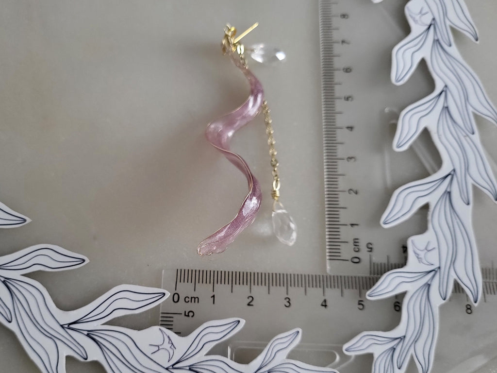 Handcrafted long golden wire earrings featuring pink cat eye resin flowers on a delicate chain with zirconia studs, waterdrop crystals, and raindrop dangles.