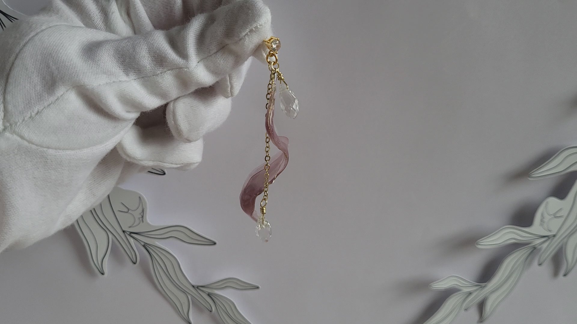 Handcrafted long golden wire earrings featuring pink cat eye resin flowers on a delicate chain with zirconia studs, waterdrop crystals, and raindrop dangles.